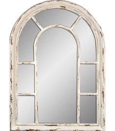 an arched window mirror with white paint on it