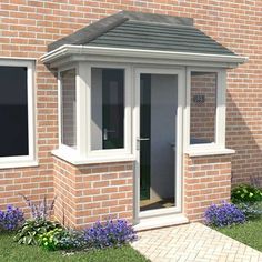 a brick building with two windows and flowers in the front