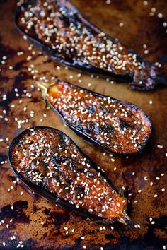 two eggplant halves covered in sesame seeds