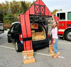 a woman standing in front of a red and black car with its doors open next to another vehicle