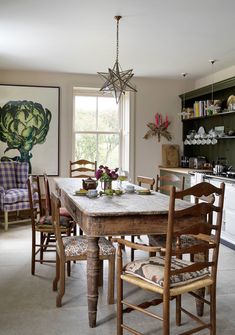 a dining room table with chairs and a chandelier hanging from it's ceiling