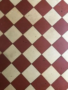 a red and white checkered floor with a cell phone on it's side