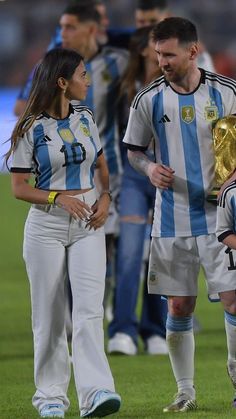 two soccer players standing next to each other on a field