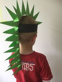 a young boy wearing a paper crown made to look like a pineapple headpiece