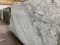 a large marble slab is being displayed in a store with other granites behind it