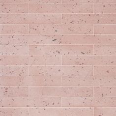 a red brick wall with small speckles on the top and bottom part,