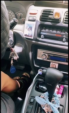 the interior of a car with an electronic device in the center console and various accessories hanging from the dash board