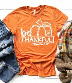 ~~Be Thankful~~ Screen printed design on a regular unisex fit short sleeve t-shirt. The color menu is for shirt color. The design is white. **The example shirt color is burnt orange** SHIRT DETAILS: -Heather Colors : 52% combed ringspun cotton & 48% polyester  -Solid Colors - 4.3 oz 100% preshrunk cotton  -Shoulder-to-shoulder taping -Double-needle stitched sleeves and bottom hem -Unisex sizes are similar to a men's style. Not fitted like a women's tee. Please see the size chart in the pics to e Nice Shirts For Women, Basic Witch Shirt, Thankful Pumpkin, Autumn Makeup, Pumpkin Spice Shirt, Mom Wardrobe, Fall Stuff, Tshirt Quilt, Virtual Wardrobe