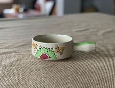 a small cup sitting on top of a bed