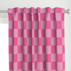 a pink checkered curtain hanging on a window