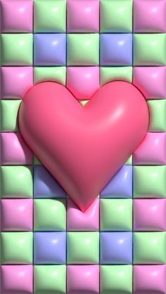 a pink heart sitting on top of a colorful tile wall