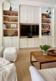 a living room filled with furniture and a flat screen tv mounted on a wall above a wooden coffee table