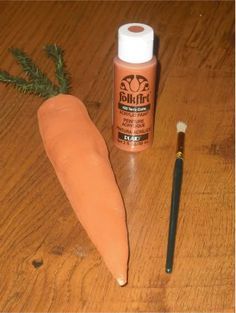 an orange carrot next to a brush on a wooden table