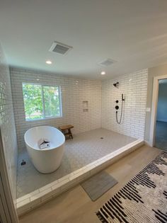 a large white bath tub sitting inside of a bathroom next to a walk in shower