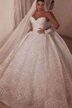 two women in wedding gowns standing next to each other