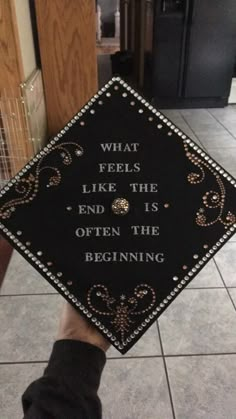 someone holding up a graduation cap that says, what feels like the end is often the beginning