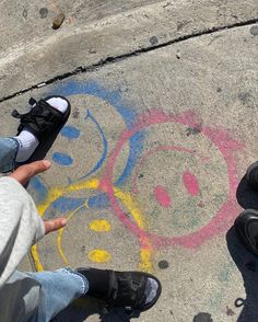 two people are standing on the sidewalk with their feet in the air and one person is pointing at something