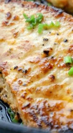 a close up of some food in a pan with green onions and meat on it