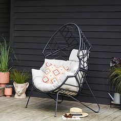 a chair sitting on top of a wooden deck next to potted plants