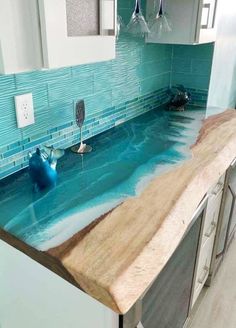 a kitchen counter with blue glass tiles on it