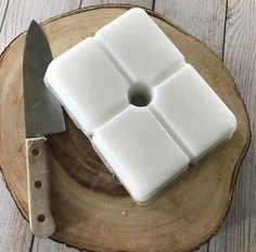 a knife and some white squares on a wooden plate