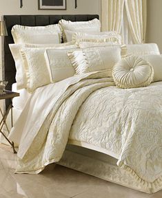 a bed with white comforters and pillows