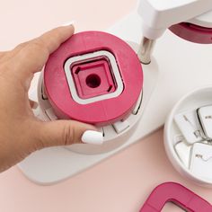 a person is pressing buttons on a pink machine