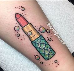 a woman's arm with a tattoo on it that has a pencil in the shape of a lipstick