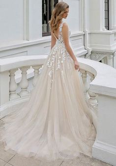 a woman in a wedding dress is standing on the balcony looking down at her back