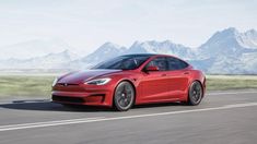 a red tesla model s is driving down the road