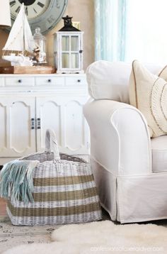 a white chair sitting next to a clock on top of a wall in a living room