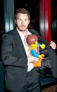 a man in a suit holding a toy