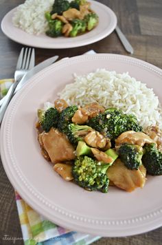 a white plate topped with chicken and broccoli covered in sauce next to rice