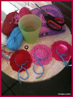 a table topped with crocheted hats and yarn