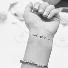 a woman's arm with a small tattoo on it that reads, let still