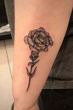 a black and white flower tattoo on the arm