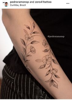 a woman's arm with flowers and leaves tattooed on the left side of her arm