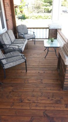 two chairs and a table on a porch