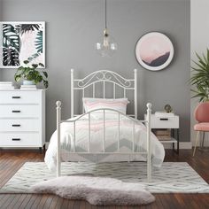 a white bed sitting on top of a wooden floor next to a dresser and chair