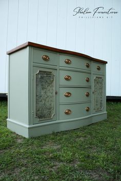 an old dresser is painted green with gold knobs