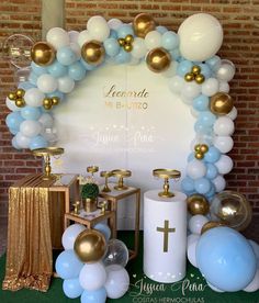 a table with balloons, candles and other items on it in front of a brick wall