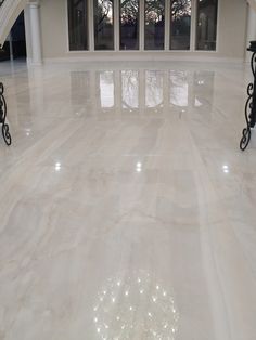 an empty room with marble floors and white columns in front of large windows on either side