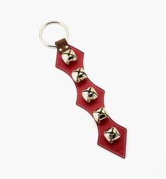 a red leather key chain with bells on it