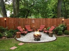 a fire pit in the middle of a yard with chairs around it and lights on