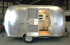 a silver trailer parked in a garage with its door open