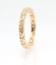 The subtle sparkle of this band is a delight! This is a 3mm patterned band with ethically sourced, 1.5 mm SI2-SI3 F+ Round Diamonds bezel set in each disc around the band. This is a cast version of a striking patterned band I originally made in fine silver using the process of Granulation. I then make a mold of the ring and pull a wax copy and then I can cast using the lost wax process in the size and metal of your choice. I am currently offering this Diamond Eternity Band in 14k yellow gold, 18 Yellow Gold Eternity Band With Decorative Details For Anniversary, Yellow Gold Decorative Eternity Band For Anniversary, Yellow Gold Eternity Band With Decorative Band For Anniversary, Gold Heirloom Half Eternity Band, Heirloom Gold Eternity Band, Heirloom Gold Half Eternity Band, Gold Elegant Eternity Band With Decorative Details, Timeless Gold Eternity Band With Diamond Cut, Heirloom Gold Eternity Band With Single Cut Diamonds