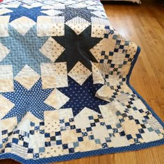 a blue and white quilt sitting on top of a wooden floor