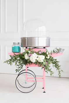 a pink cart with flowers on the wheels