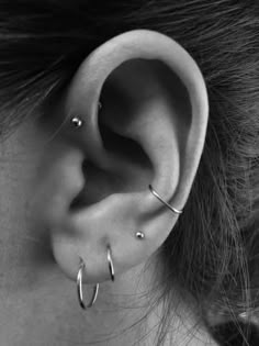 a close up of a person's ear with two piercings on the side