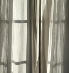 an open window with sheer curtains in front of it